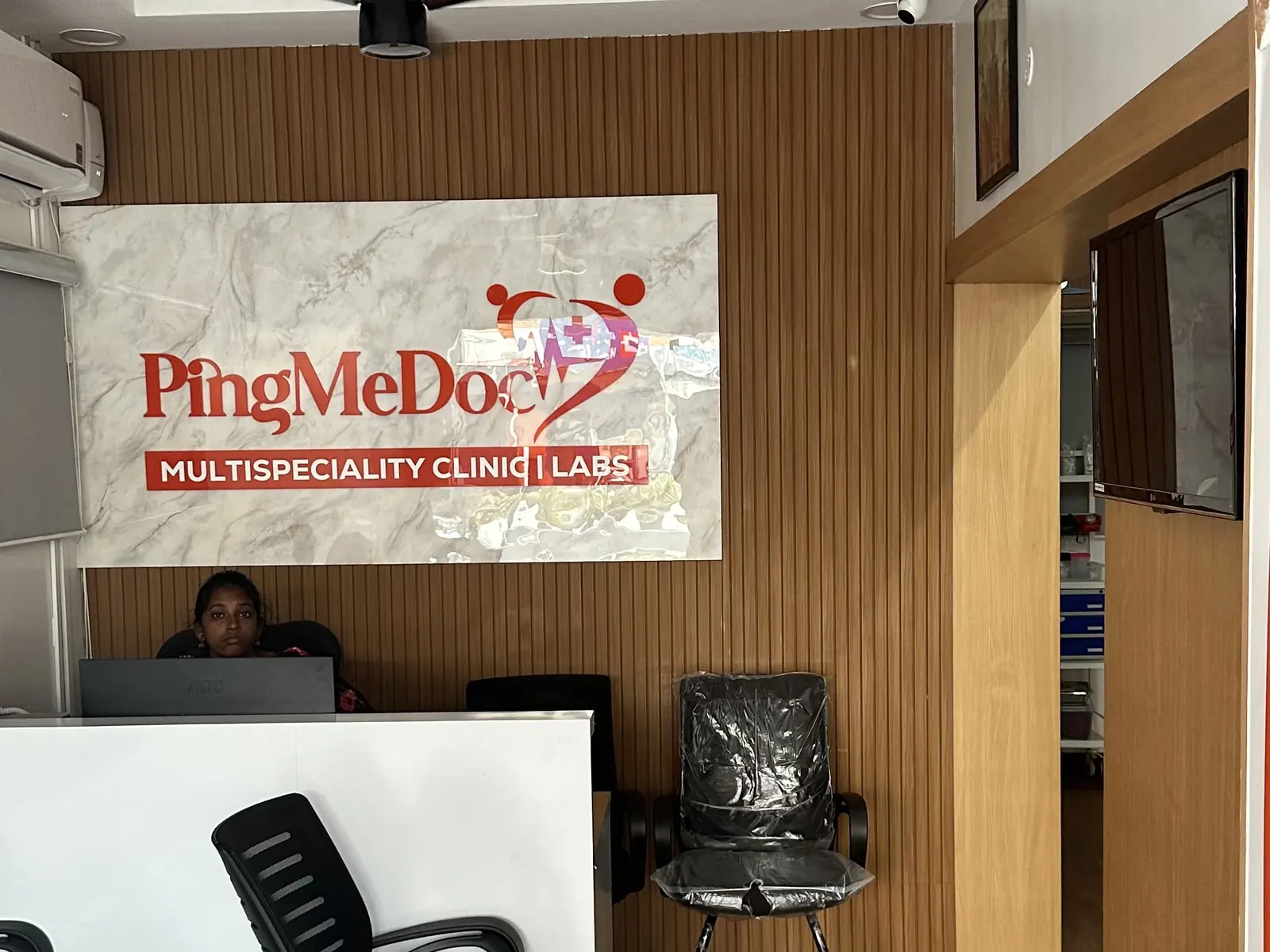 Reception desk and waiting chairs at PingMeDoc Multispeciality Clinic, Kandigai